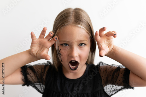 Obraz na płótnie Close up portrait of little girl growling with claw hands for Halloween