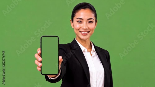 Asian Woman Holding Smartphone with Green Screen Display Toward Camera, Mobile App Mockup, Digital Presentation, Blank Screen, Business Technology, Isolated Background