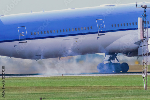  An airplane lands on the runway with Tire Smoke and Hot air is escaping from the engines.