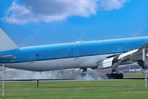  An airplane lands on the runway with Tire Smoke and Hot air is escaping from the engines.