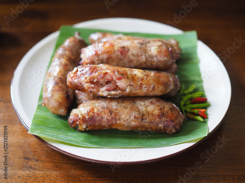 Fotografía Grilled pork sausage is placed on a banana leaf on a plate