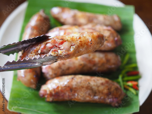Cuadro en lienzo Grilled pork sausage is placed on a banana leaf on a plate