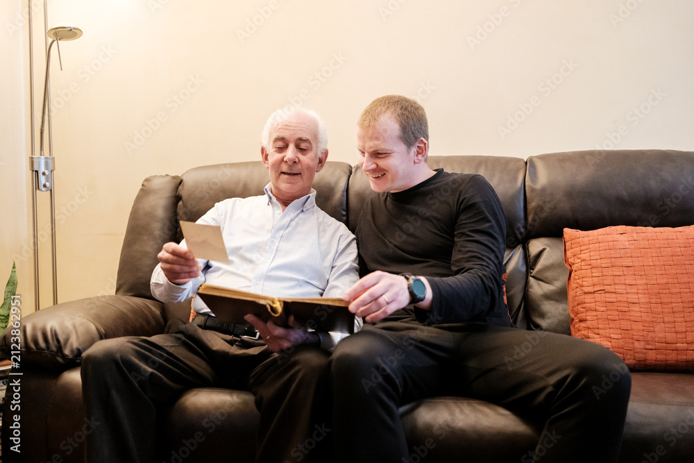 Fototapeta premium Generations bonding looking through family history album