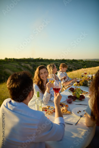 Foto Women raising rose wine glasses during cheerful summer toast outdoors