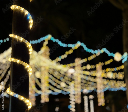 Twinkling string lights wrapped around a pole at night