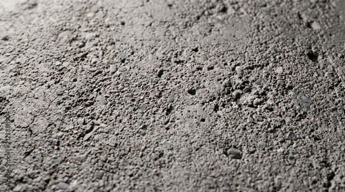 Close up view of grey concrete floor texture with rough surface and tiny gravel bits