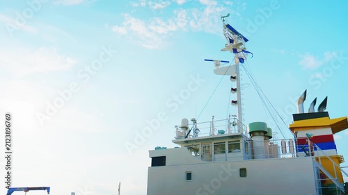 Cargo ship superstructure and mast against bright blue sky