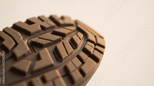 The shoe sole showcases its rugged texture and design, hinting at outdoor adventures. A close-up reveals the gripping patterns designed for traction and durability.