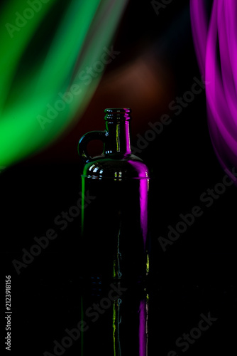 Silhouette of glass bottle with colorful abstract neon light background