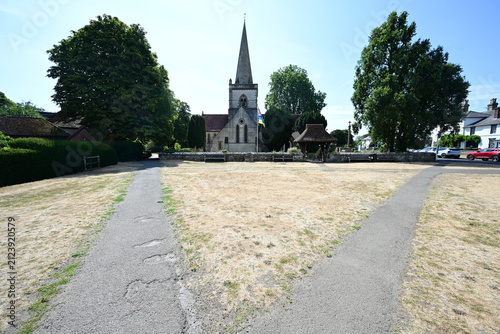 Church behind an arid green during the heatwave of August 3rd 2026 in the UK.