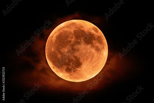Fiery full moon glows ominously through wisps of dark, smoky clouds
