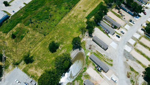 Obraz na płótnie Expansive grassy fields border southern neighborhood perimeters near localized water retention features