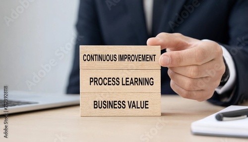 Professional holding wooden blocks emphasizing continuous improvement process learning and business value concepts