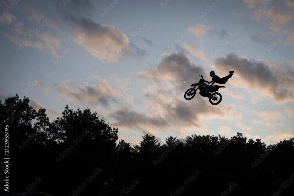 Fototapeta premium sunset silhouette of a motocross biker in air