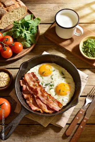 Rustic Farmhouse Breakfast with Fried Eggs Bacon Fresh Bread and Garden Vegetables