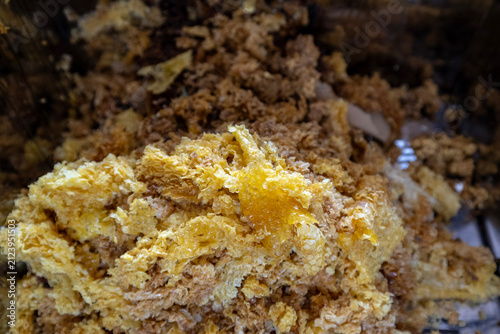 Fotografie Broken beeswax honeycomb pieces after mechanical honey extraction
