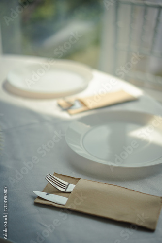 Restaurant table setting with white plate and cutlery