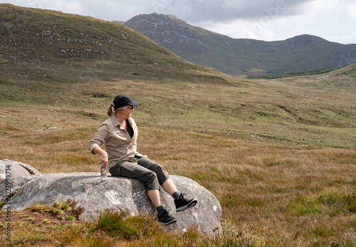 Woman sitting on a rock in Connemara Ireland