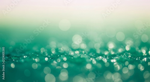 Dreamy abstract background with teal green and pale yellow bokeh mimicking polished jade surface