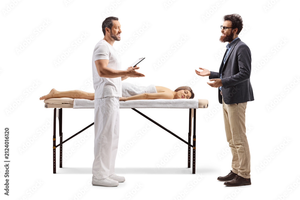 Obraz premium Male massage therapist talking to a man next to a female client