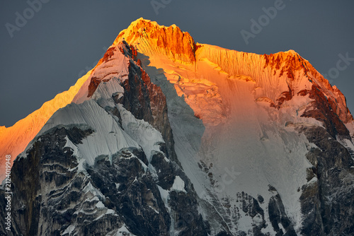 Foto Golden alpenglow ignites the massive east face of Yerupaja, the highest peak in