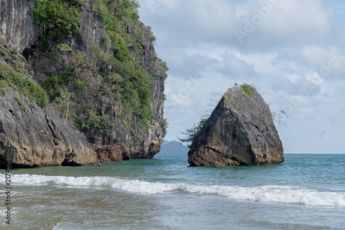 Limestone cliffs rising above waves on tropical beach