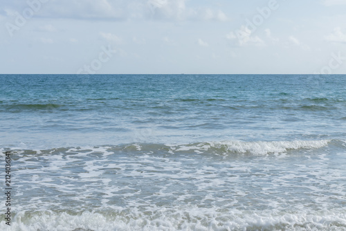 Ocean waves rolling toward shore under cloudy sky