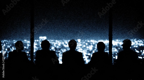 Silhouettes of five people sitting and facing a cityscape illuminated by numerous bright lights at night.