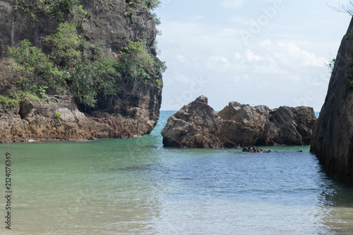 Rocky cliffs surrounding a calm tropical bay