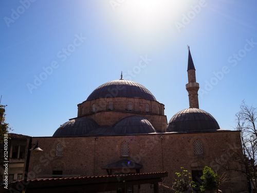 Fotografie Mosque with domes and minaret against a clear blue sky