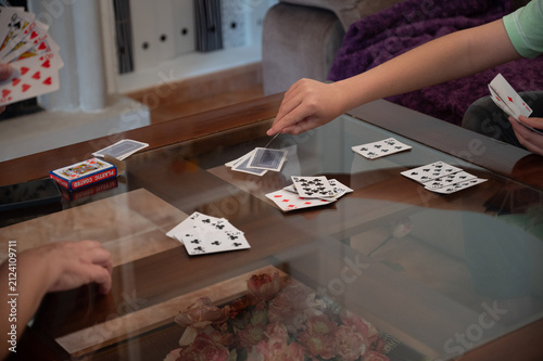 Teenage boy drawing a card during a family card game at home