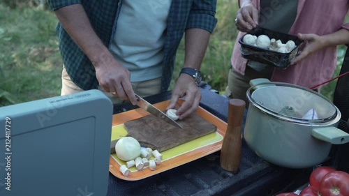 Couple preparing a meal together while camping outdoors