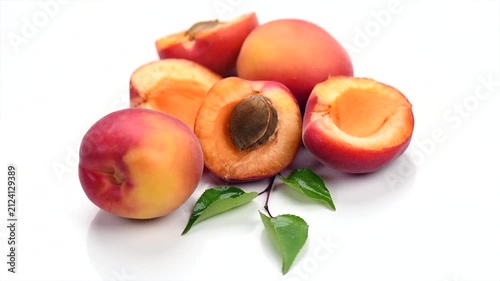 Apricots. Close-up of fresh organic apricot fruits isolated on white background. Fresh bio apricot with leaves, rotating.  
