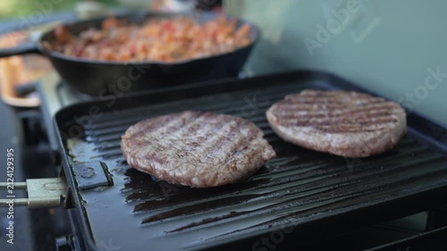 Beef hamburger patties sizzling on outdoor grill