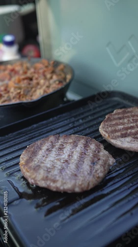 Beef burgers cooking on an outdoor camping grill