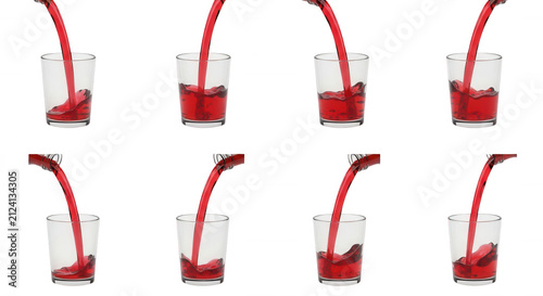 red liquid being poured into glass cups against a white background drink related or refreshment concepts