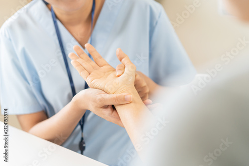 Close up of a physical therapist massaging and examining a patient hand for wrist and trigger fingers rehabilitation, carpal tunnel syndrome and office syndrome occupational therapy medical concept.