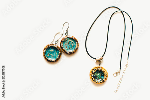 Jewelry made of ceramics. Ceramic earrings and pendant. Turquoise earrings on a white background. Handmade jewelry on a white background.