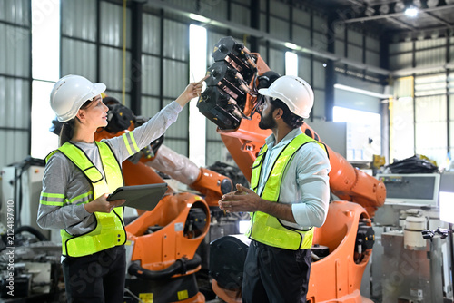 Team examines robotic technology inside a factory in the afternoon