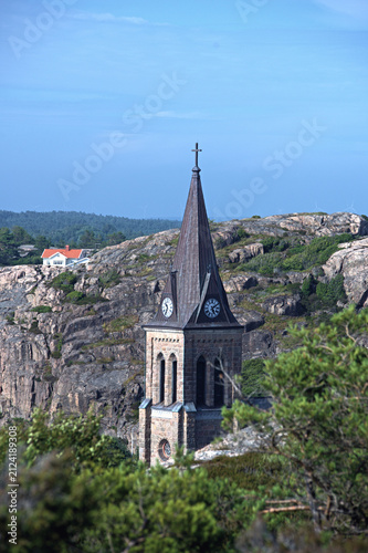 Canvas Print Stone church spire rising above granite rocks in Sweden