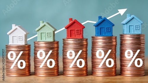 Colorful stacked coins with growing houses symbolizing real estate investment growth and profit