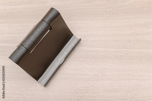 Black phone stand on a wooden table. Top view.