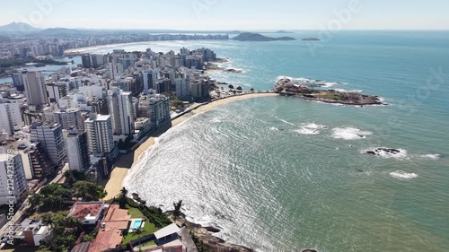 Panoramic aerial drone view of Guarapari, Espírito Santo, Brazil, with tropical beaches, turquoise Atlantic Ocean, urban coastline, rocky shores and mountains in the background.	

