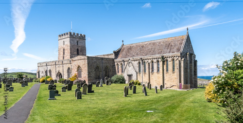 Exterior of a Church in Bamburgh, showcasing historic stonework and simple coastal architecture set against the backdrop of the seaside village.