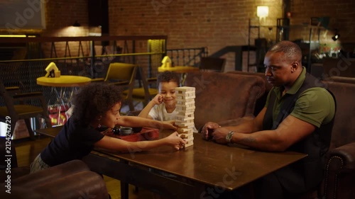 Black family enjoying wooden block tower game together
