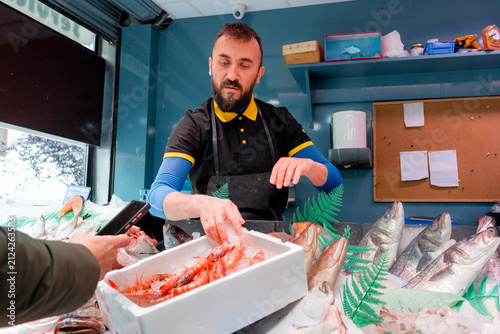 Fishmonger weigh fresh seafood at local fish shop
