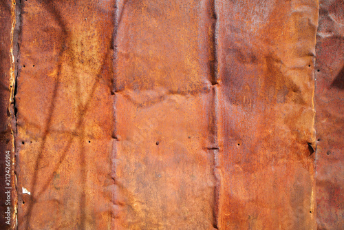 close-up texture of a heavily rusted, weathered sheet of corrugated metal.