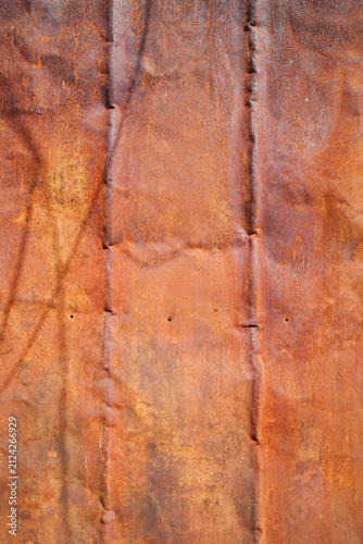 close-up texture of a heavily rusted, weathered sheet of corrugated metal.