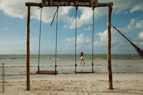 Fotografía Rustic wooden swings installed on a sandy beach against blue sky and tropical sea