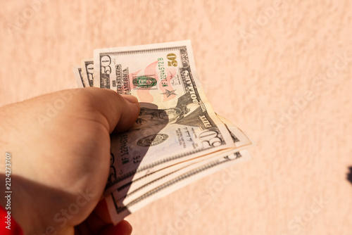 Canvas Print Man hand holding United States Dollar banknotes showing paper texture and symbol
